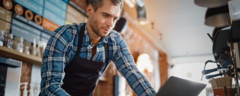 Coffe shop worker using laptop 5x2