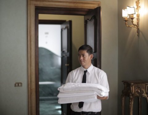 Hotel staff member holding linens