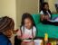 Krystal Larsosa helps her daughter, Klir, 7, with homework while her other daughter, Kady Robinson-Larsosa, works on homework at their home in west Detroit.