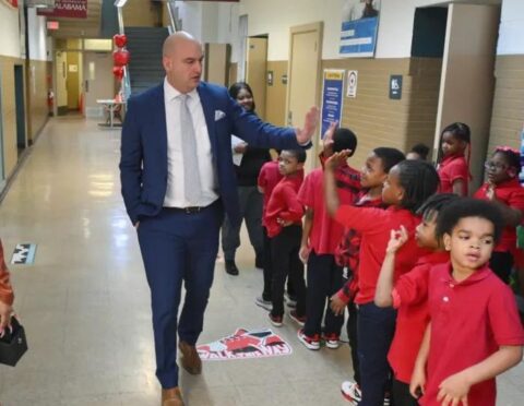 Detroit Public Schools Community District Superintendent Nikolai Vitti slaps hands with students