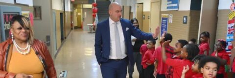 Detroit Public Schools Community District Superintendent Nikolai Vitti slaps hands with students
