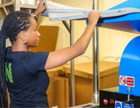 Sabina Montinar, director of operations at Detroit-based textile recycling company NextTiles LLC, loads a machine to produce building insulation made of recycled pre-consumer fabric from auto manufacturers and fashion designers.