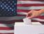 A ballot box with the American flag behind it.