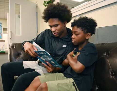 Nijuel Stewart reads a book to Caleb Smith during an activity at a day camp at Rosedale Park Baptist Church.