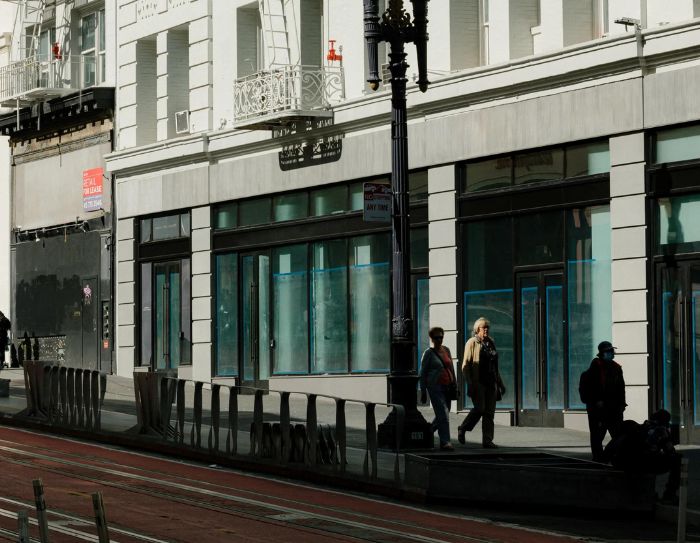Pedestrians pass vacant retail stores on Powell Street in San Francisco on May 13, 2023.