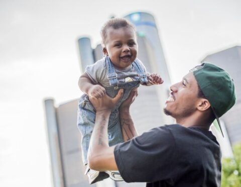 A man holding up a baby