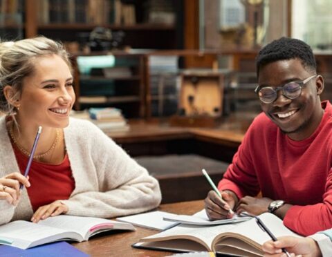 Two students smiling while working on homework