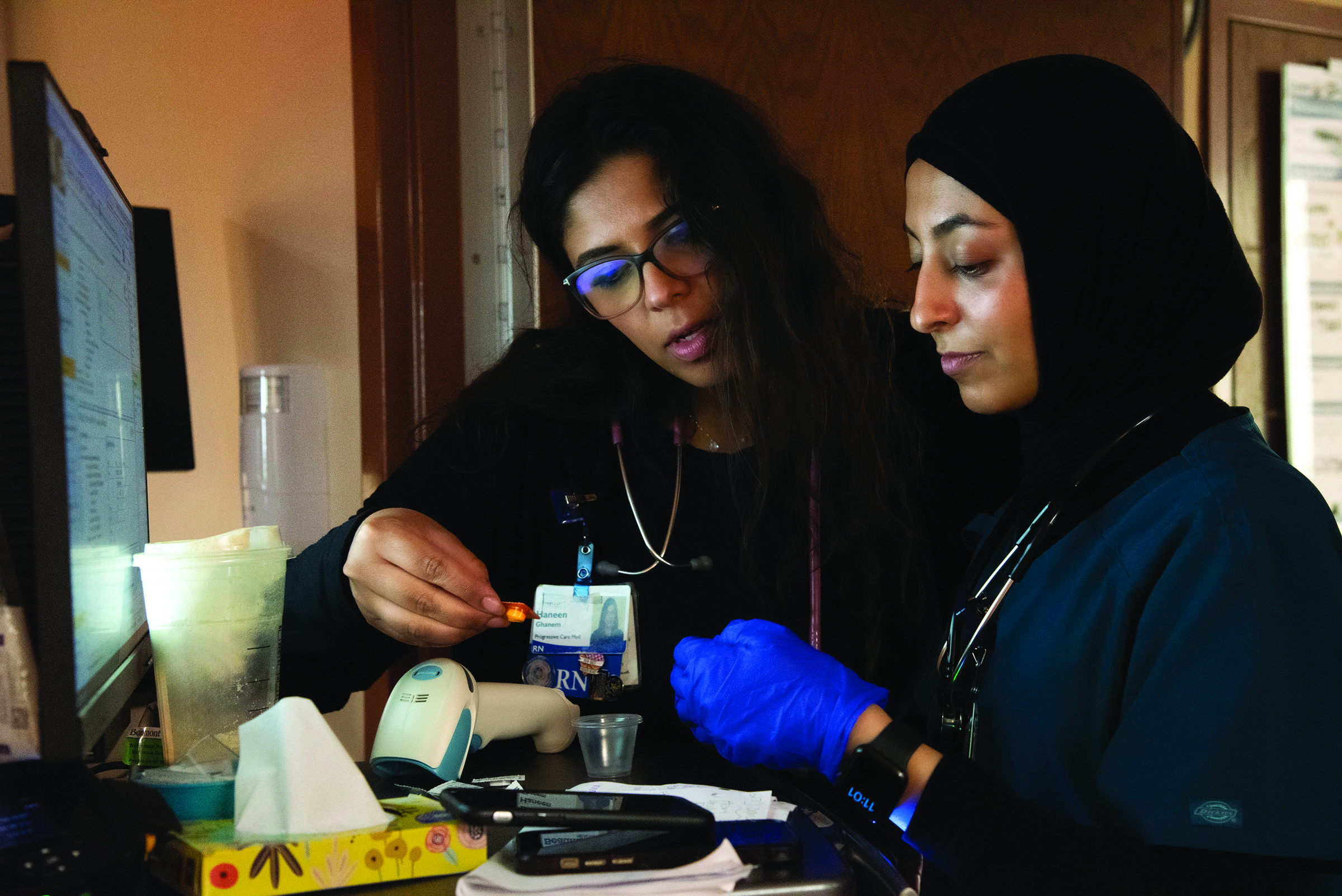 Maha Alfakih PRN right, and Haneen Granem PRN confering over medication for a patient. Corewell Health Dearborn hospital