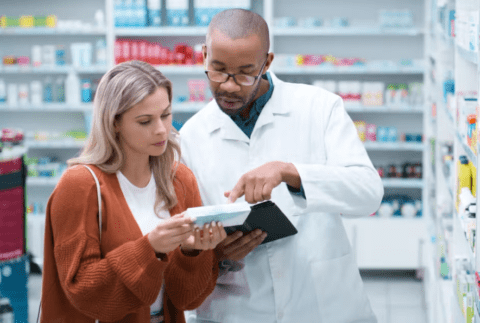 male pharmacist and woman looking at a product in a pharmacy