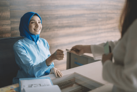 two women exchanging documents at the hospital