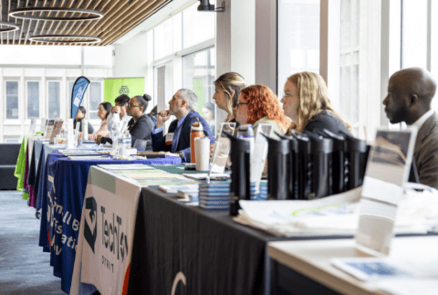 different people sitting at tables looking ahead