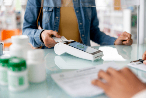 a person paying for a prescription at a pharmacy