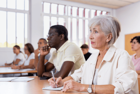 Mature woman with other adult different ages students in studying with their colleagues